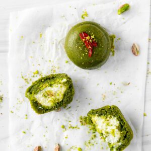 Tasty pistachio dessert flat lay with cream filling and bright garnishes.